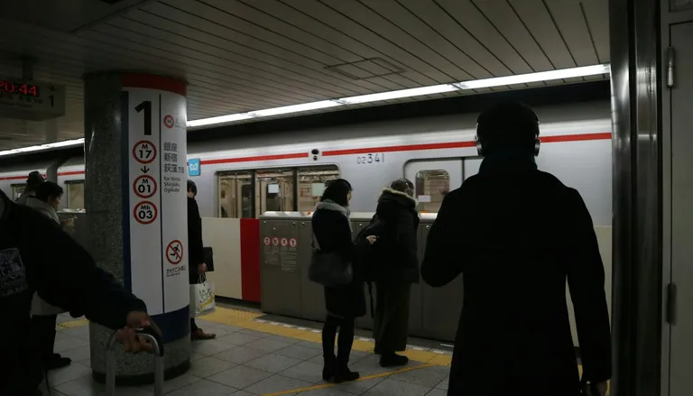 電車が着いた東京の地下鉄ホームで待つ乗客
