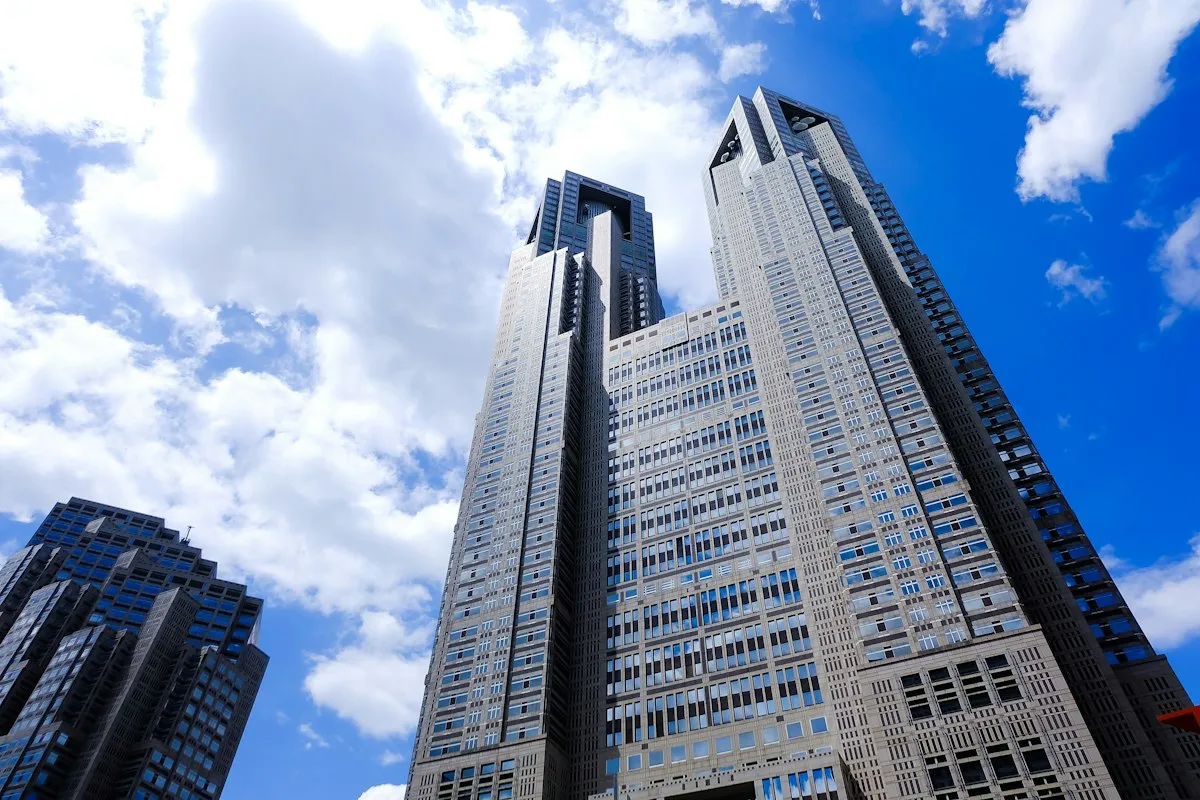 The twin towers of the Tokyo Metropolitan Government Building in Nishi-Shinjuku against a blue sky