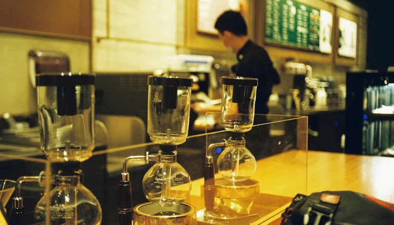 落ち着いた木の色の喫茶店のカウンターに並ぶサイフォン