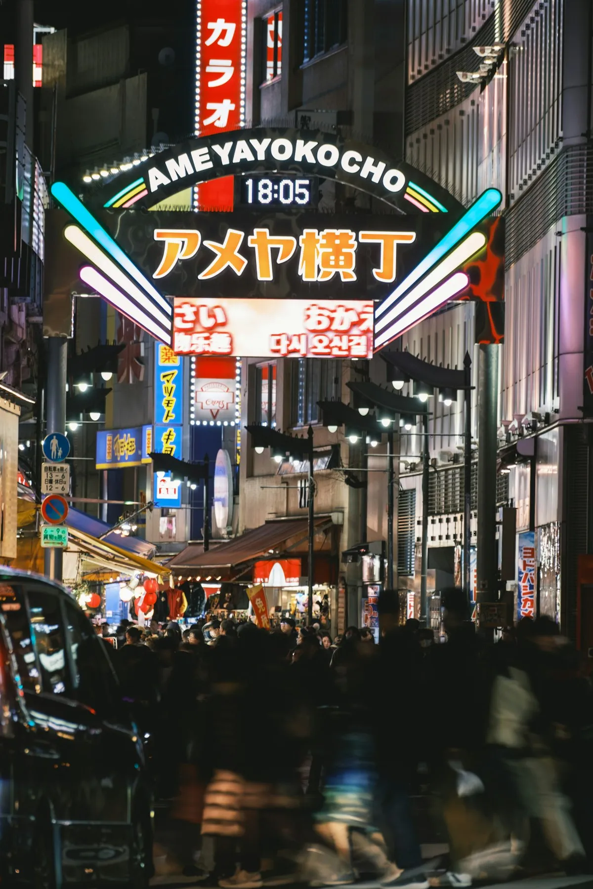 The neon Ameyoko gate at night, with shoppers crowding the street below